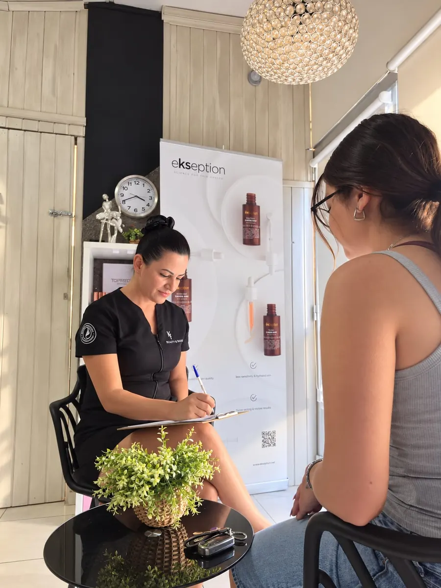 Koulla taking notes during a skin consultation